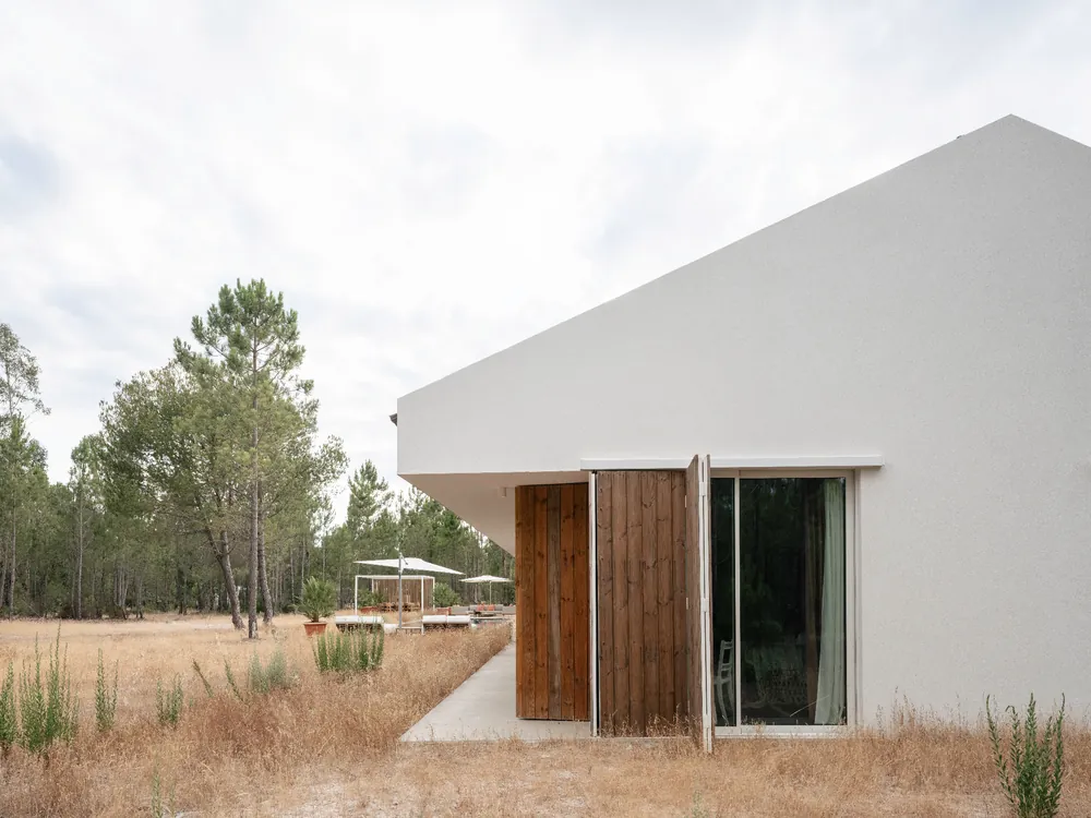Wood-shuttered entry cantilever facing the pinewood.