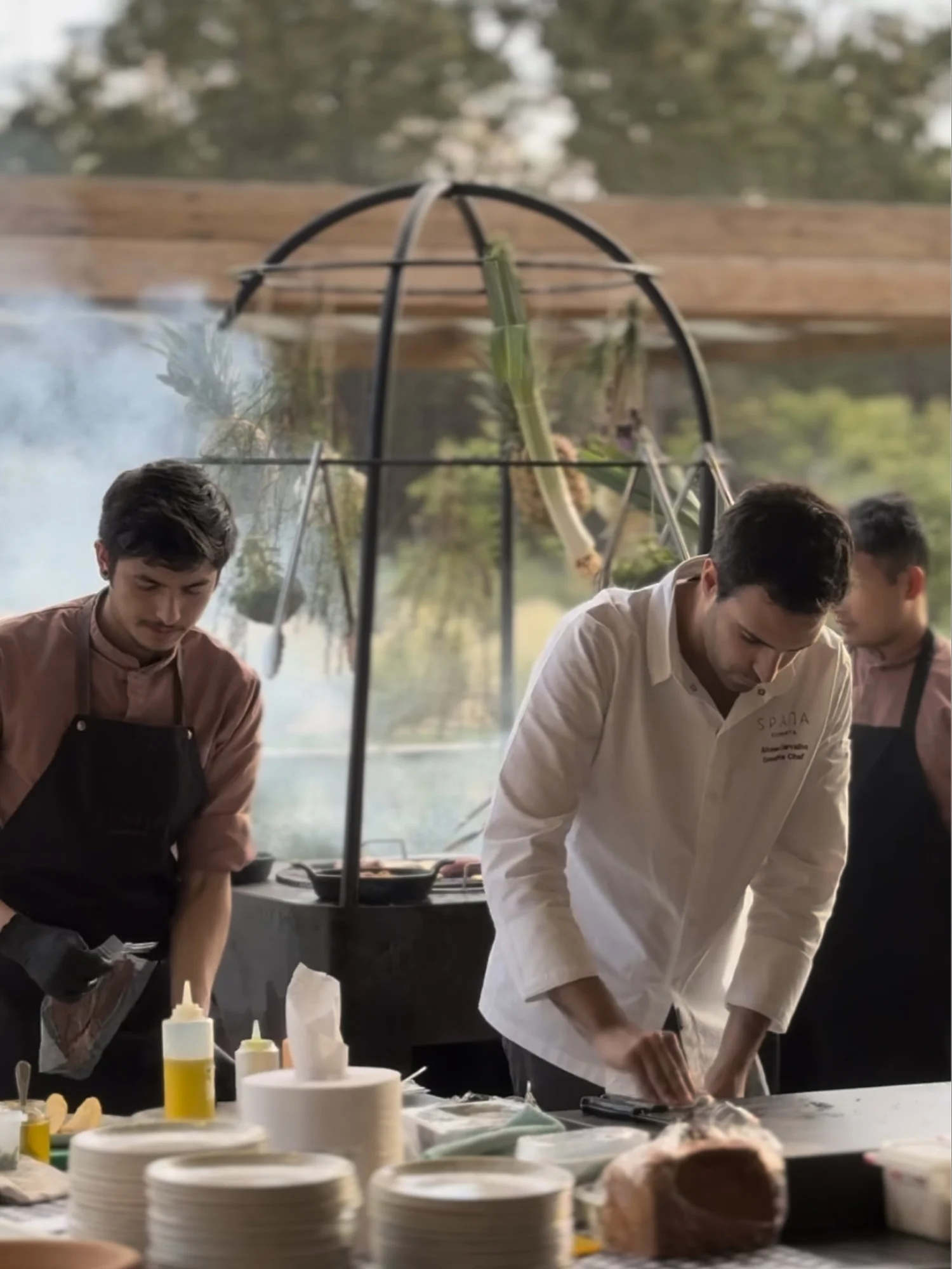 Chefs preparing a live-fire dinner at the resort's outdoor kitchen.